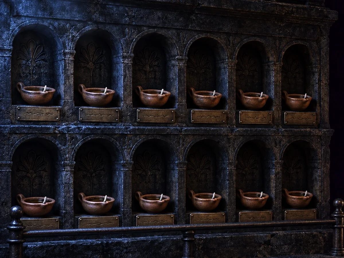 Douze lampes à huile dans leurs niches de pierre, éteintes et prêtes, chacune sous son nom gravé, derrière une barre de fer scellée